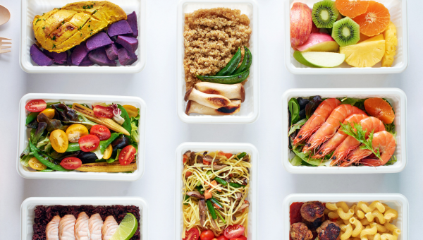 An array of colorful meal prep containers filled with healthy food options.