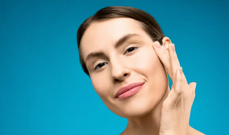 Woman touching her smooth skin, highlighting facial rejuvenation benefits