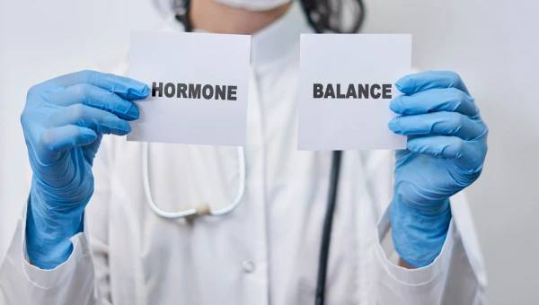 Doctor holding cards with 'Hormone' and 'Balance' written on them